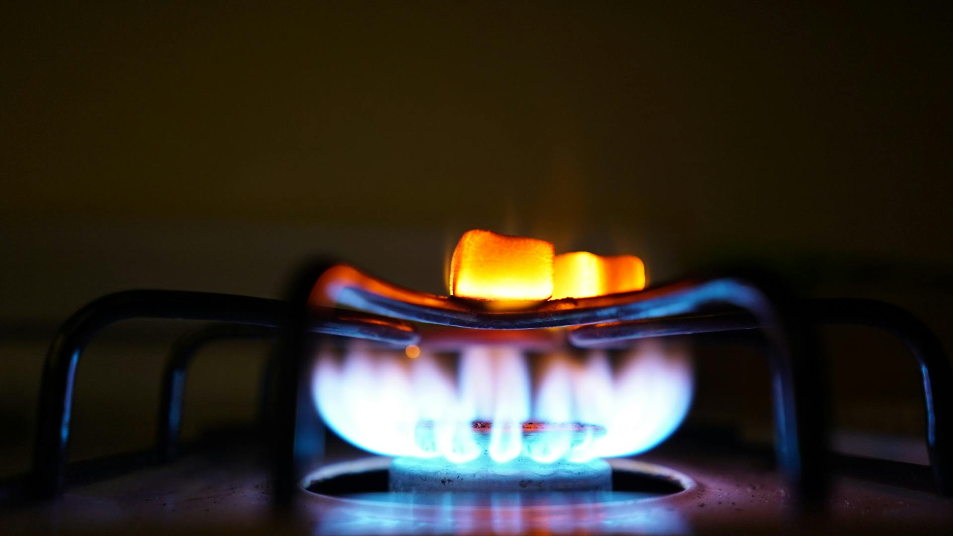 Home Roasting marshmallows over an indoor gas stove for a cozy treat.